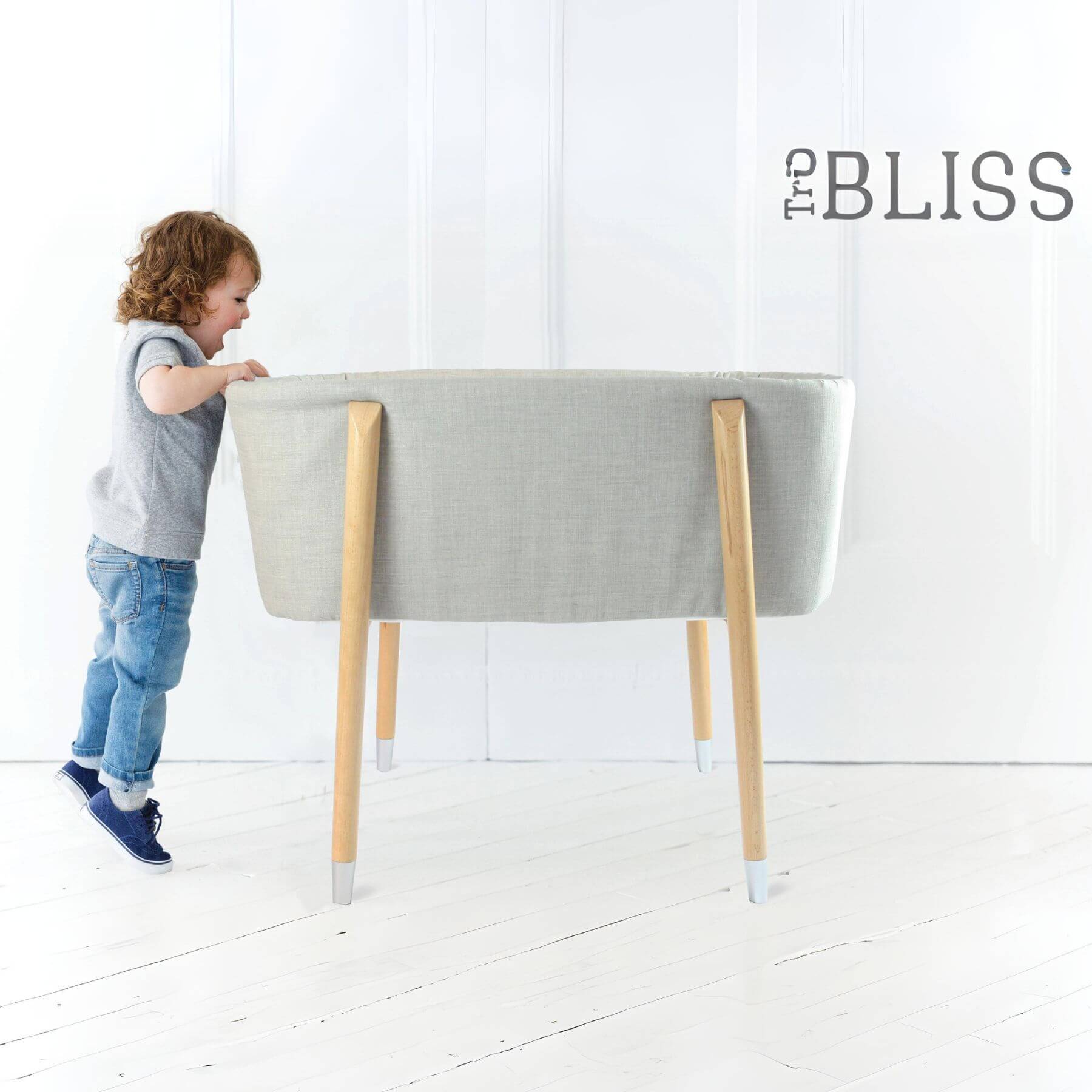 Kid Looking into TruBliss SOVA Bassinet Grey