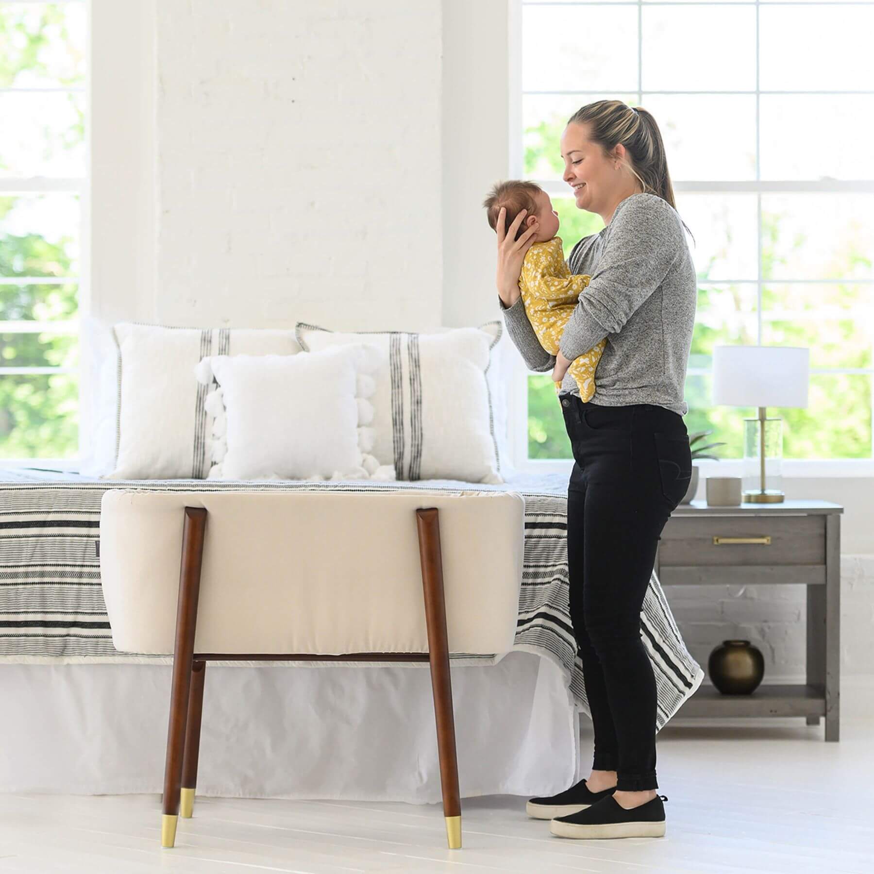 Mom Holding Baby next to TruBliss SOVA Bassinet Irish Cream