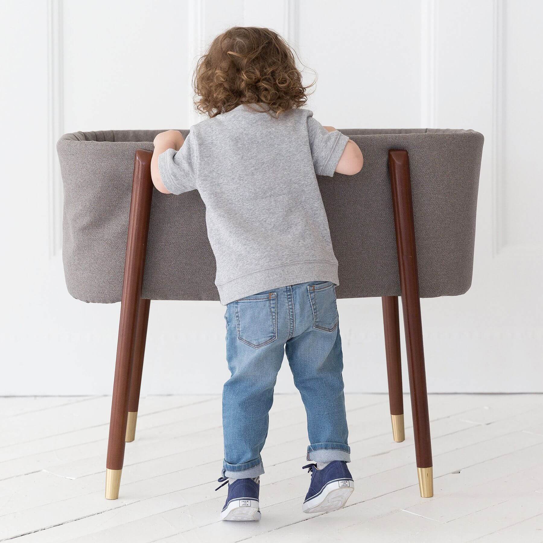 Kid Looking into TruBliss SOVA Bassinet London Grey