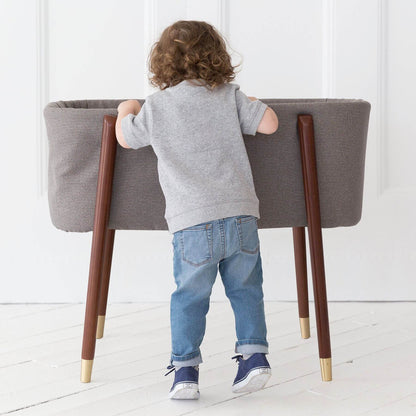 Kid Looking into TruBliss SOVA Bassinet London Grey