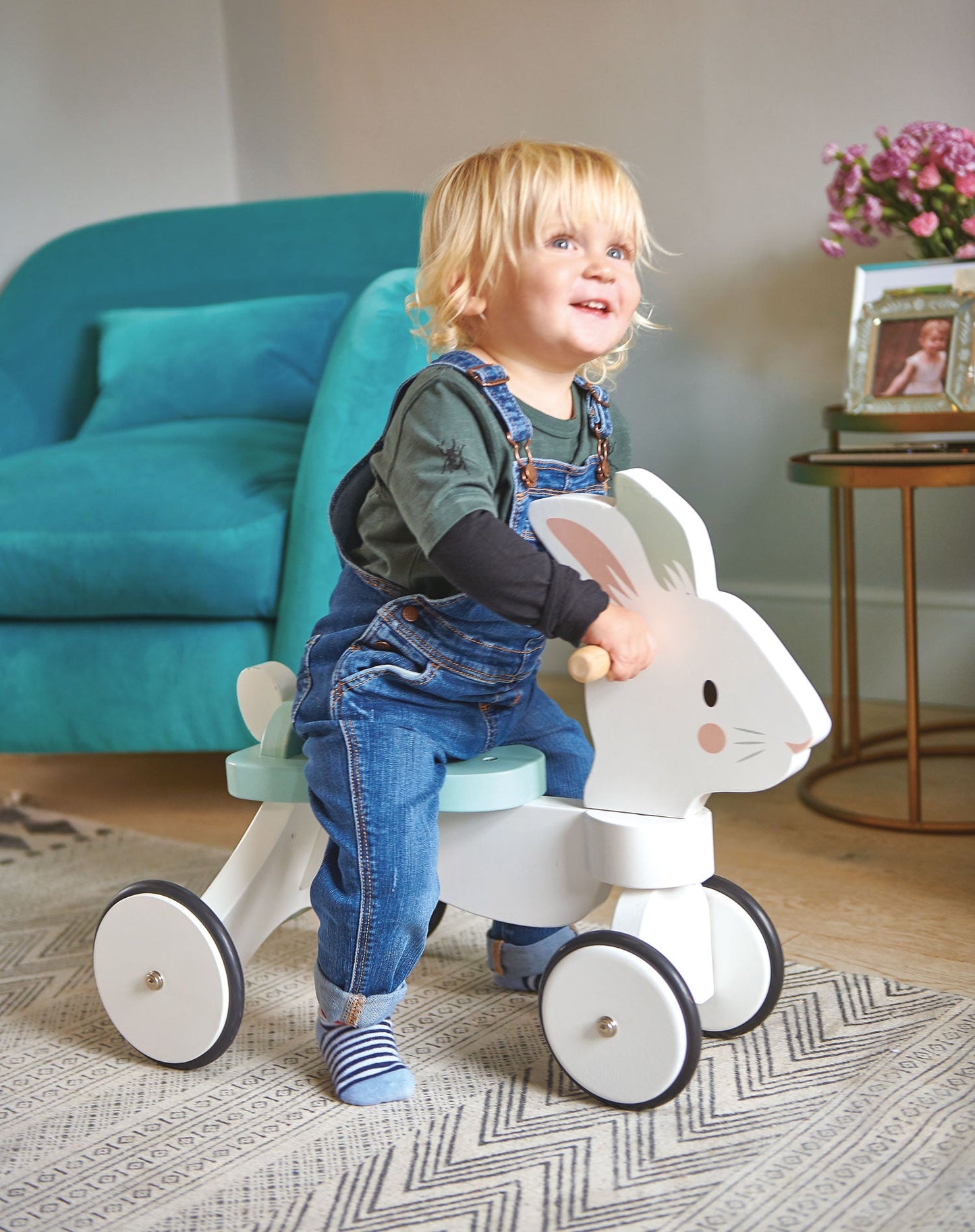 Child riding Tender Leaf Running Rabbit Ride Onin a living room.