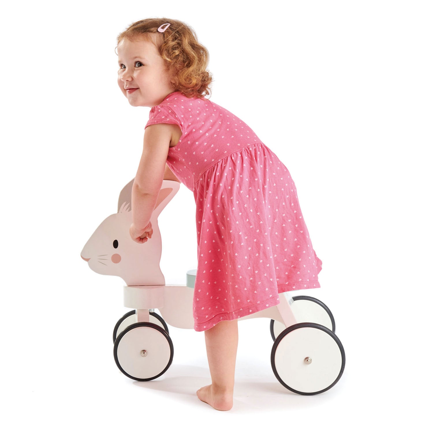 Child in a pink dress riding Tender Leaf Running Rabbit Ride On