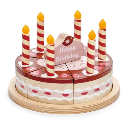 Wooden birthday cake toy with candles and a 'Happy Birthday' card on a white background