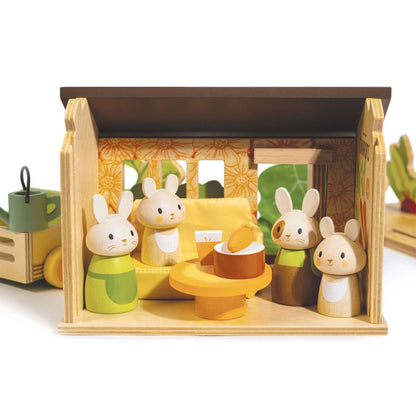 Wooden toy set with rabbit figures and a house-like structure on a white background