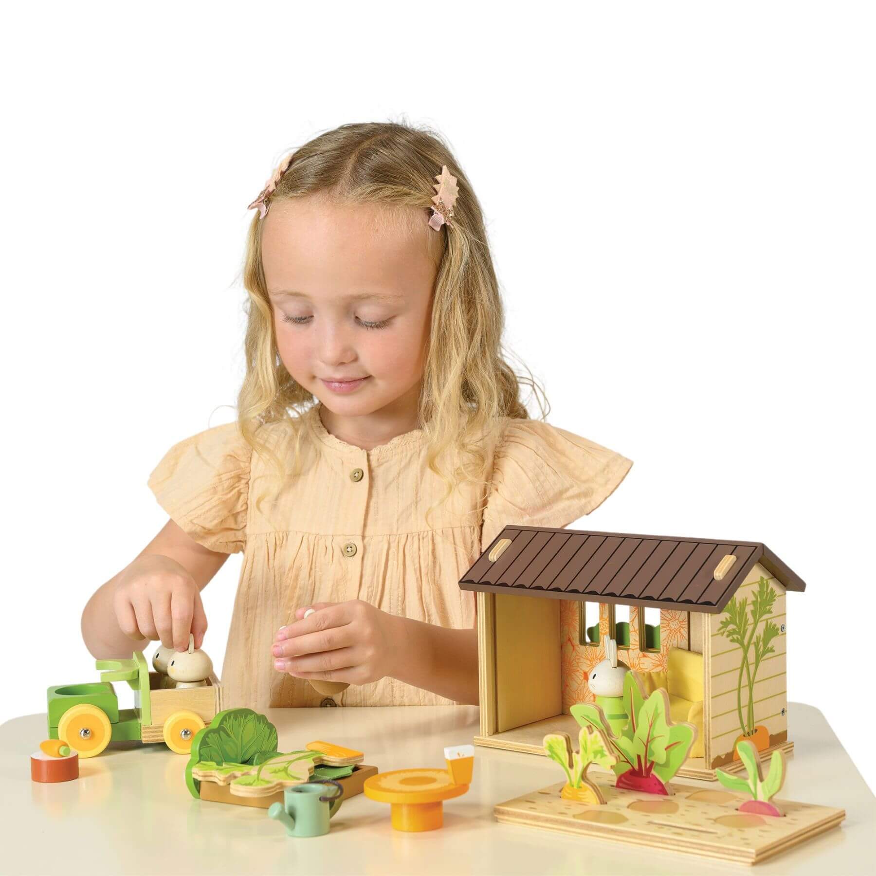 Young girl playing with Tender Leaf Bunny's Carrot Patch on a white background