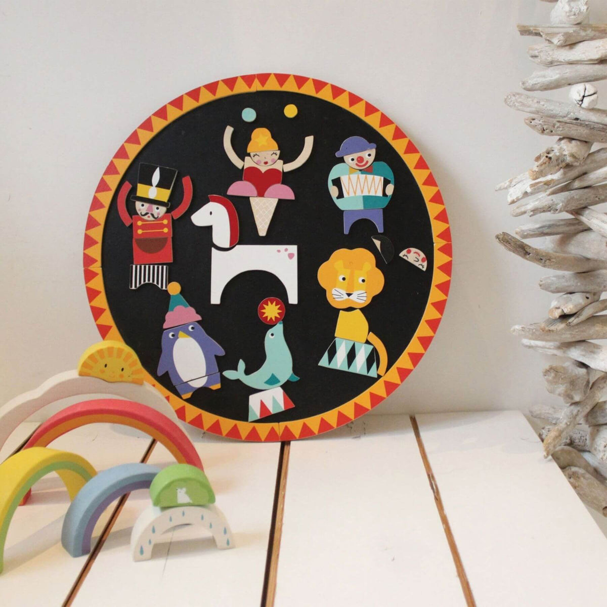 Tender Leaf Circus Night, displayed on a white surface with small rainbow arches and driftwood decor nearby.