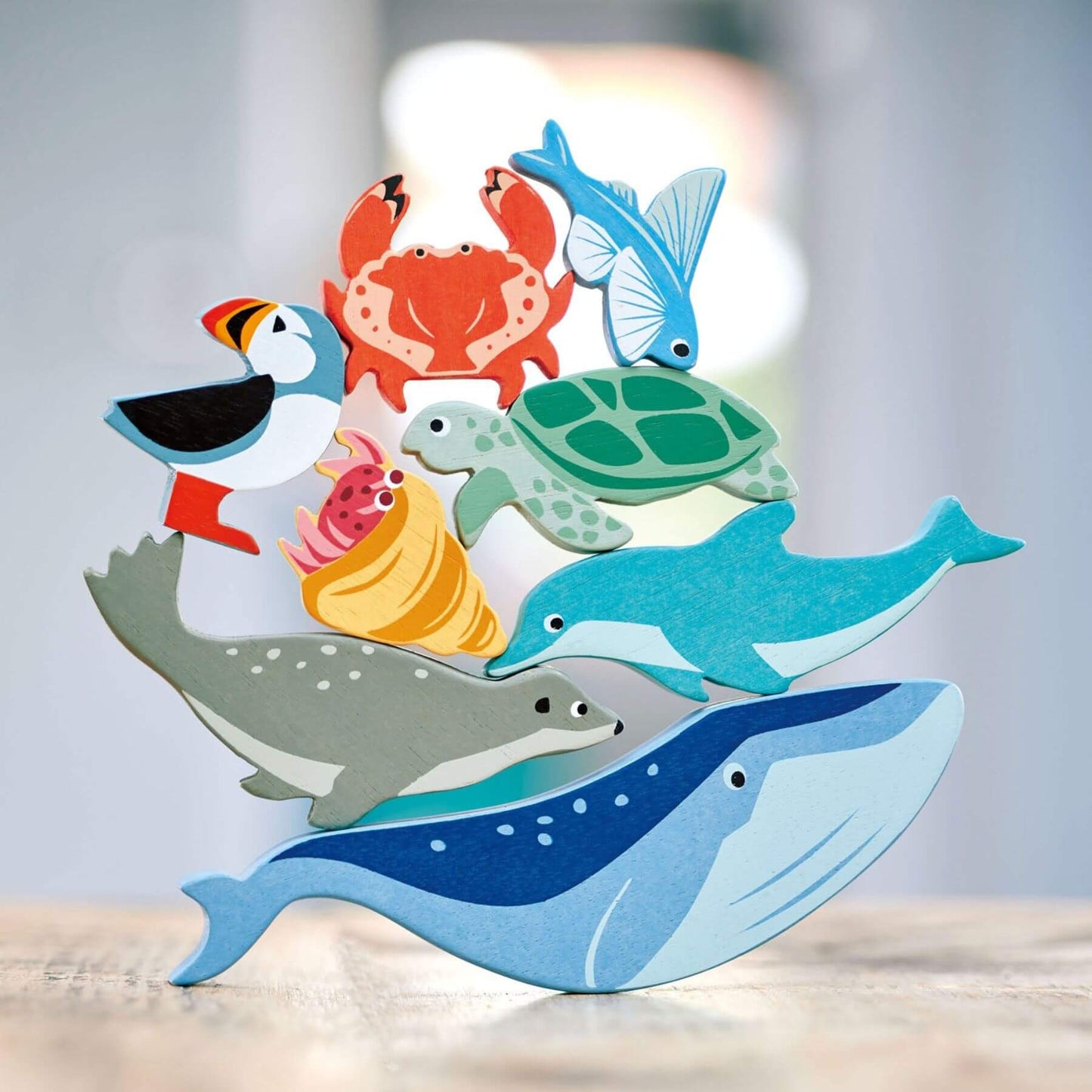 Set of colorful sea creature toys on a wooden surface with a blurred background