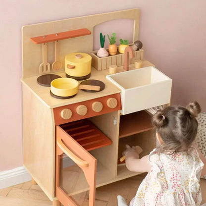 Child playing with Tiny Land® Cubby Kitchenette - Natural in a room.