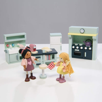Toy kitchen set with two dolls in a kitchen scene on a white background