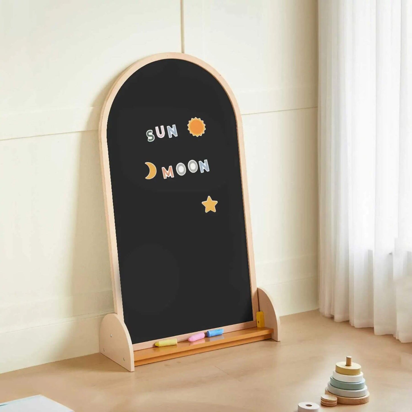 Children's blackboard with wooden frame and decorative elements on a light-colored floor.