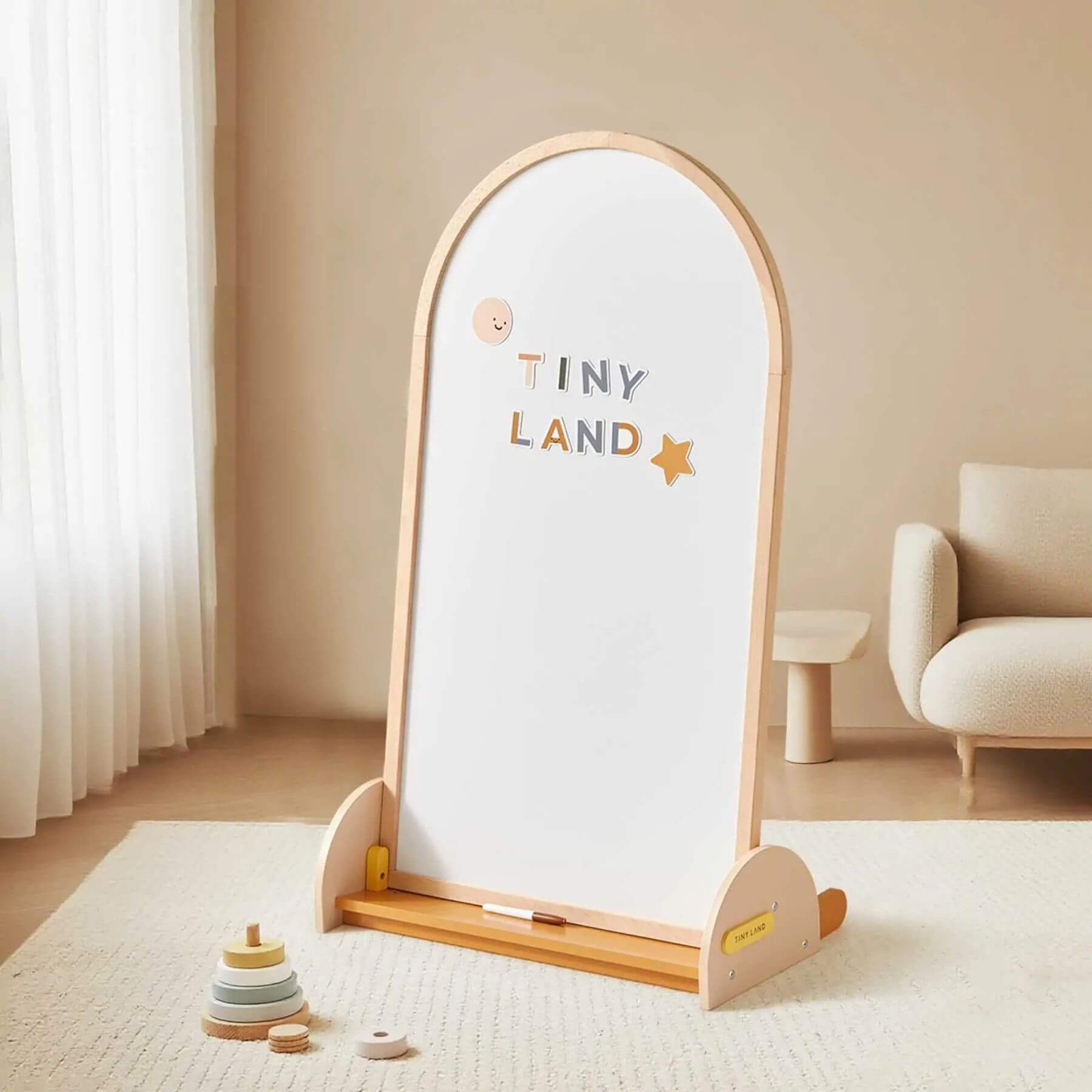 Tiny Land® Double-Sided Arched Magnet Chalkboard with 'Tiny Land' text in a room with a chair and toys.