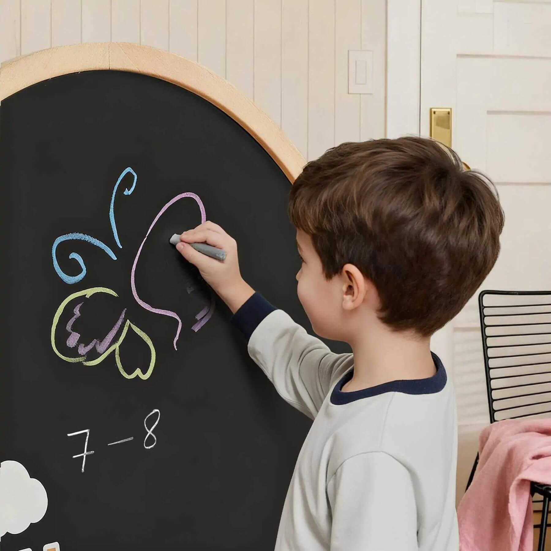 Child drawing on a blackboard with colorful chalk