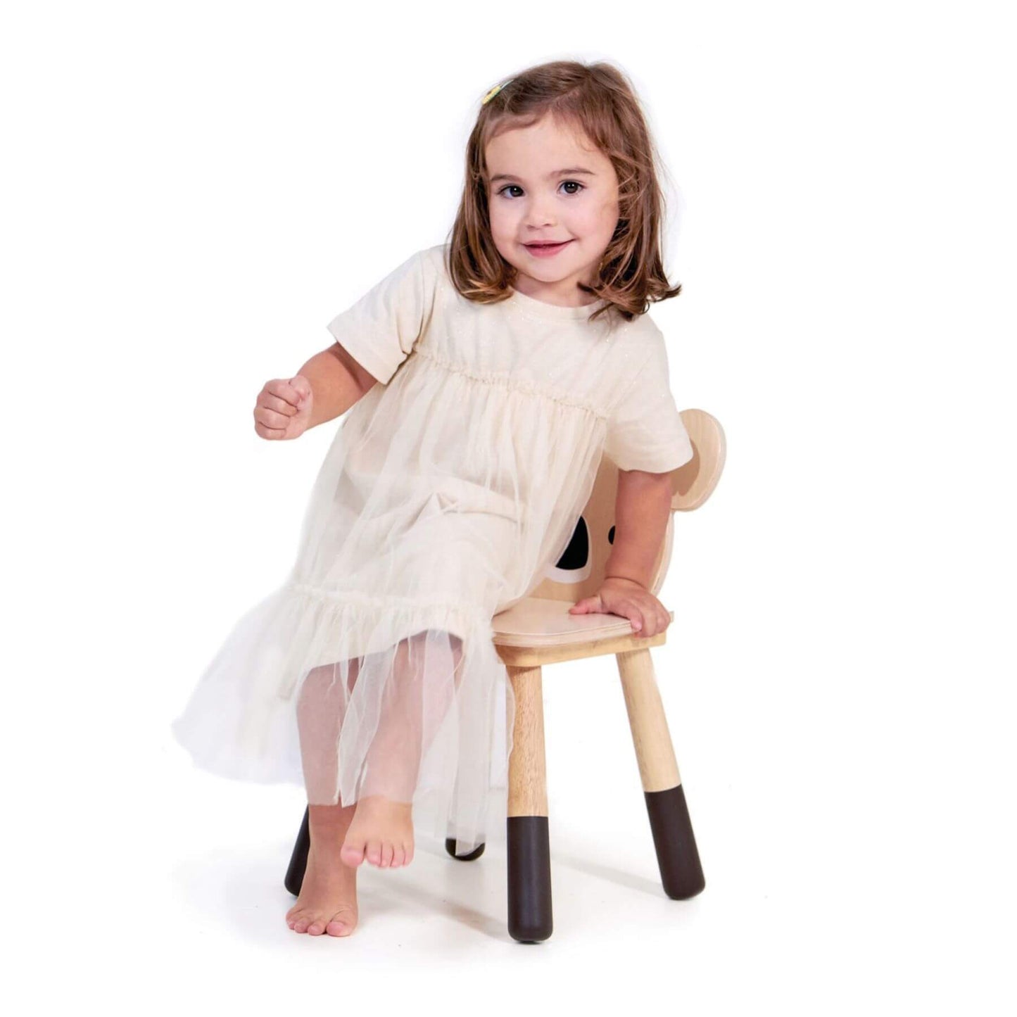 Young girl sitting on Tender Leaf Forest Koala Chair wearing a white dress with sheer overlay.