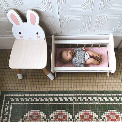 Children's room with Tender Leaf Forest Rabbit Chair and a small bed with a baby doll on a patterned floor.