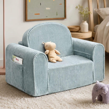 Tiny Land® GentleSnug Corduroy Kid Chair - Teal, styled in a nursery with a teddy bear on the seat, a plush elephant toy on the rug, and a wooden bed in the background.