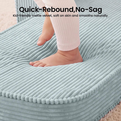A close-up of Tiny Land® GentleSnug Corduroy Kid Chair - Teal, with a child's foot and lower leg resting on it. Text at the top reads 'Quick-Rebound, No-Sag' and 'Kid-friendly matte velvet, soft on skin and smooths naturally.