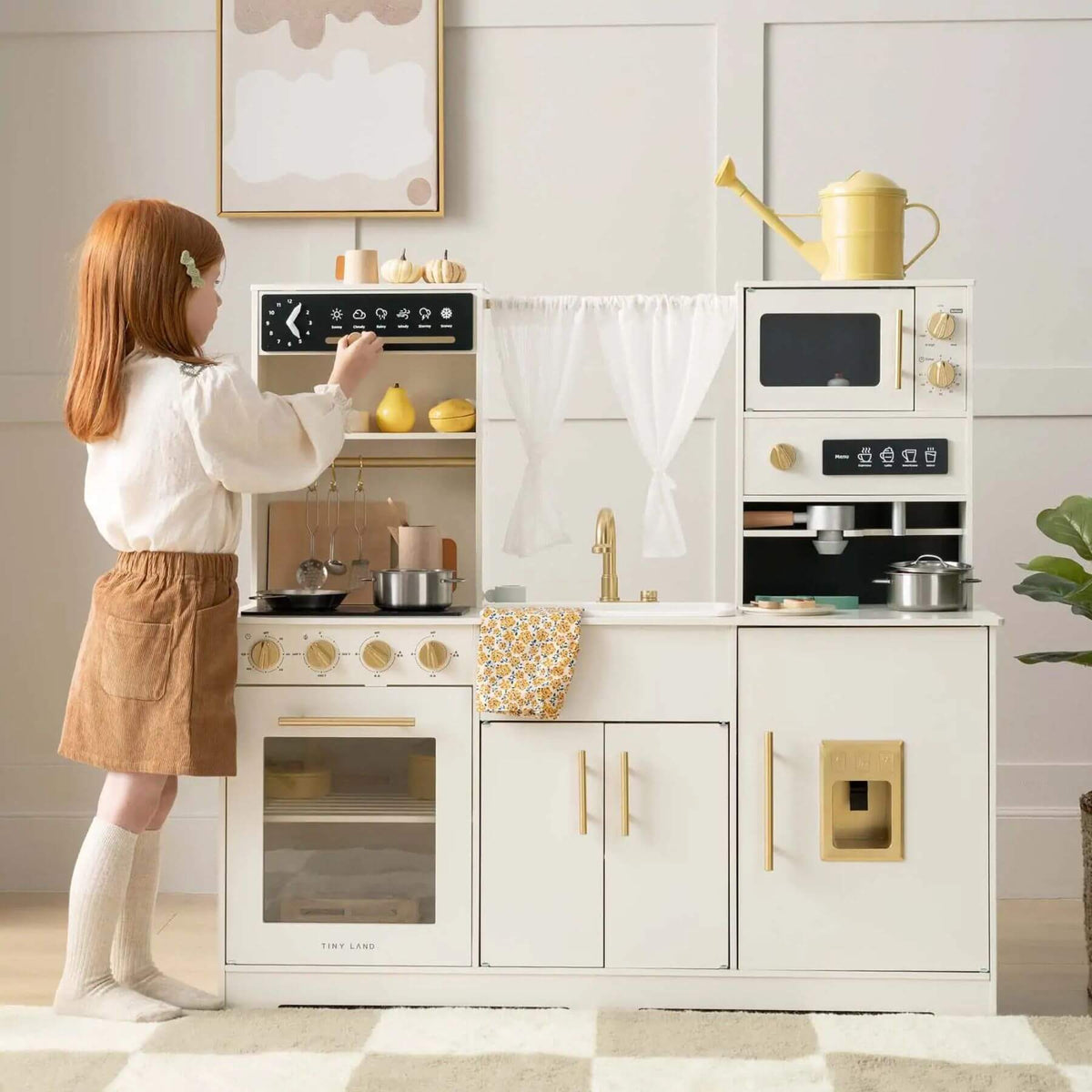 A young girl beside Tiny Land® Play Kitchen with Running Water - Iconic Aqua Kitchen in Cream.