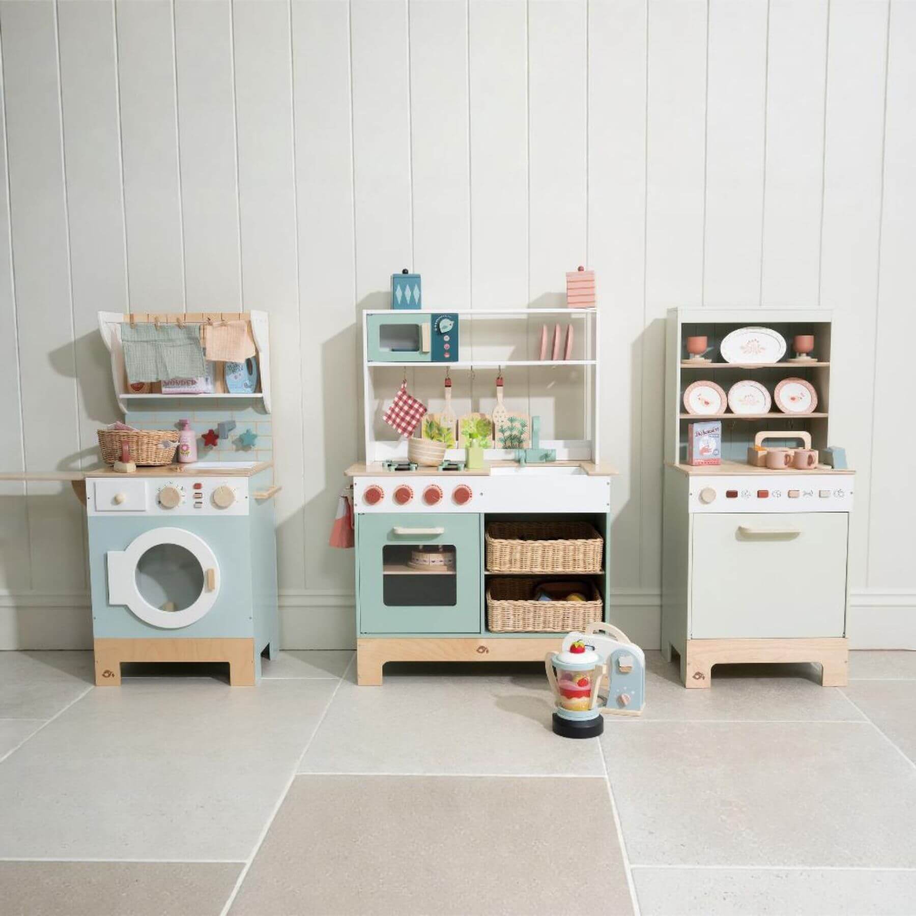Children's play kitchen set with various appliances and items on a tiled floor.