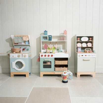 Children's play kitchen set with various appliances and items on a tiled floor.