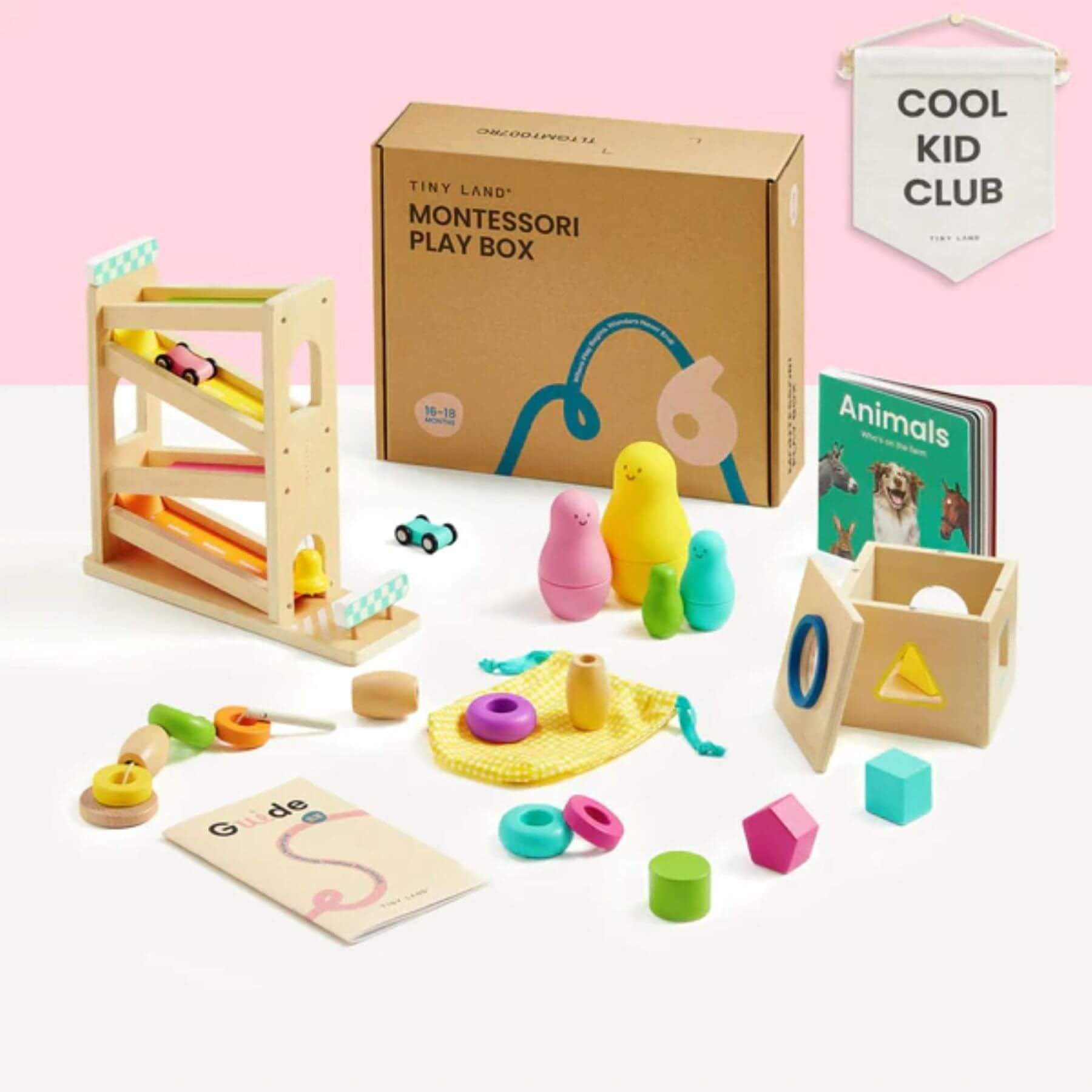 Montessori play box with colorful wooden toys and educational materials on a pink background.