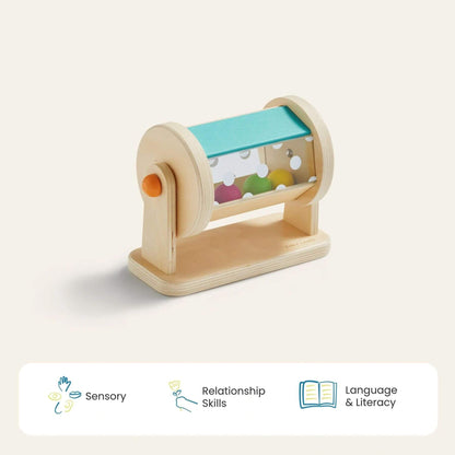 Wooden toy with colorful balls inside, labeled for sensory, relationship, and language skills on a light background.