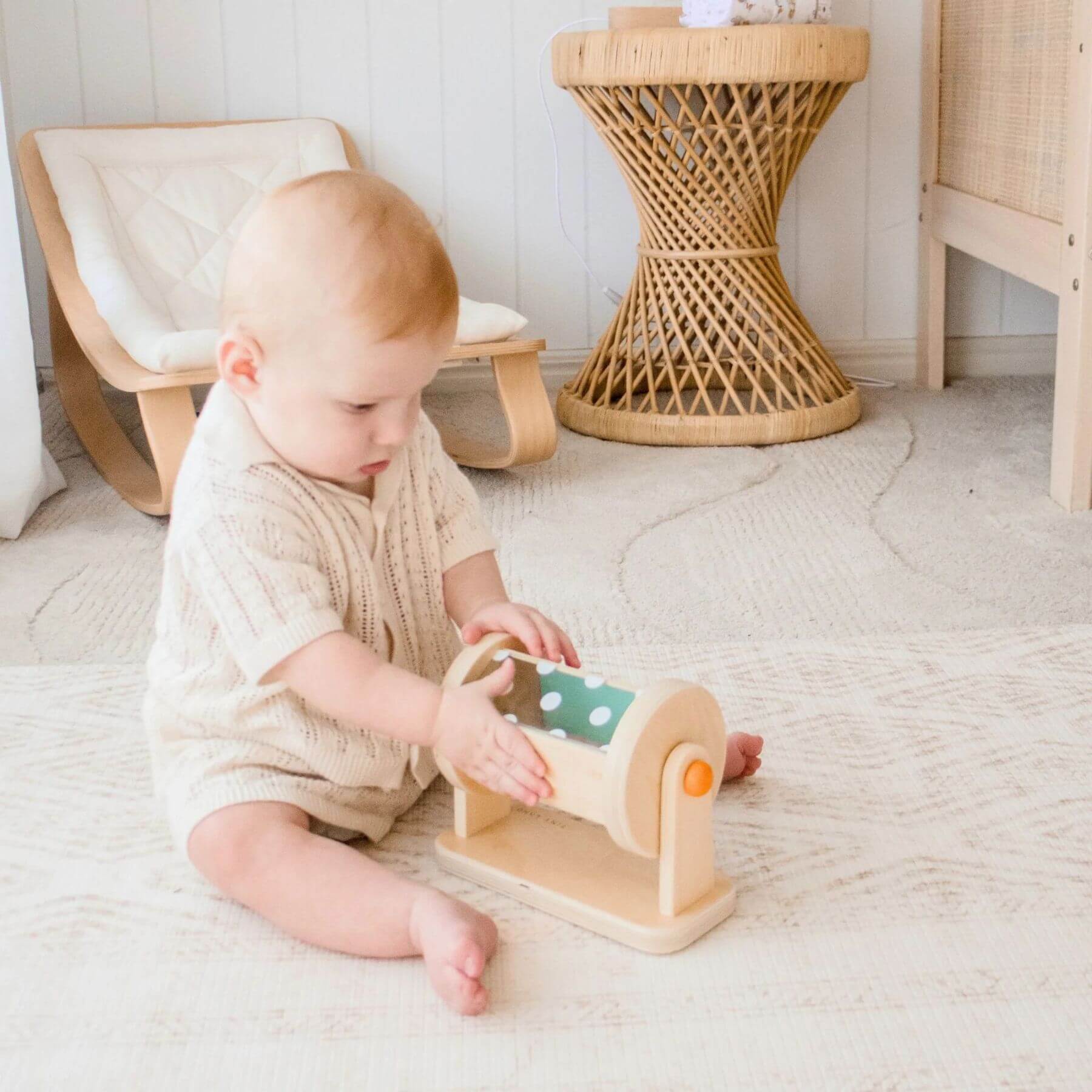 Child playing with a wooden toy on a light-colored floor.