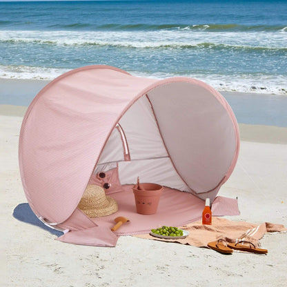 Pink beach tent on a sandy beach with ocean view