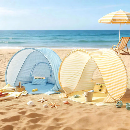Two beach tents on a sandy beach with ocean view and beach accessories.