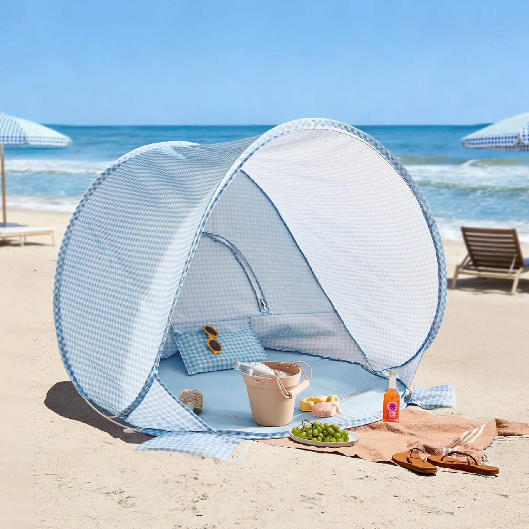 Beach tent with a picnic setup on a sandy beach with ocean view