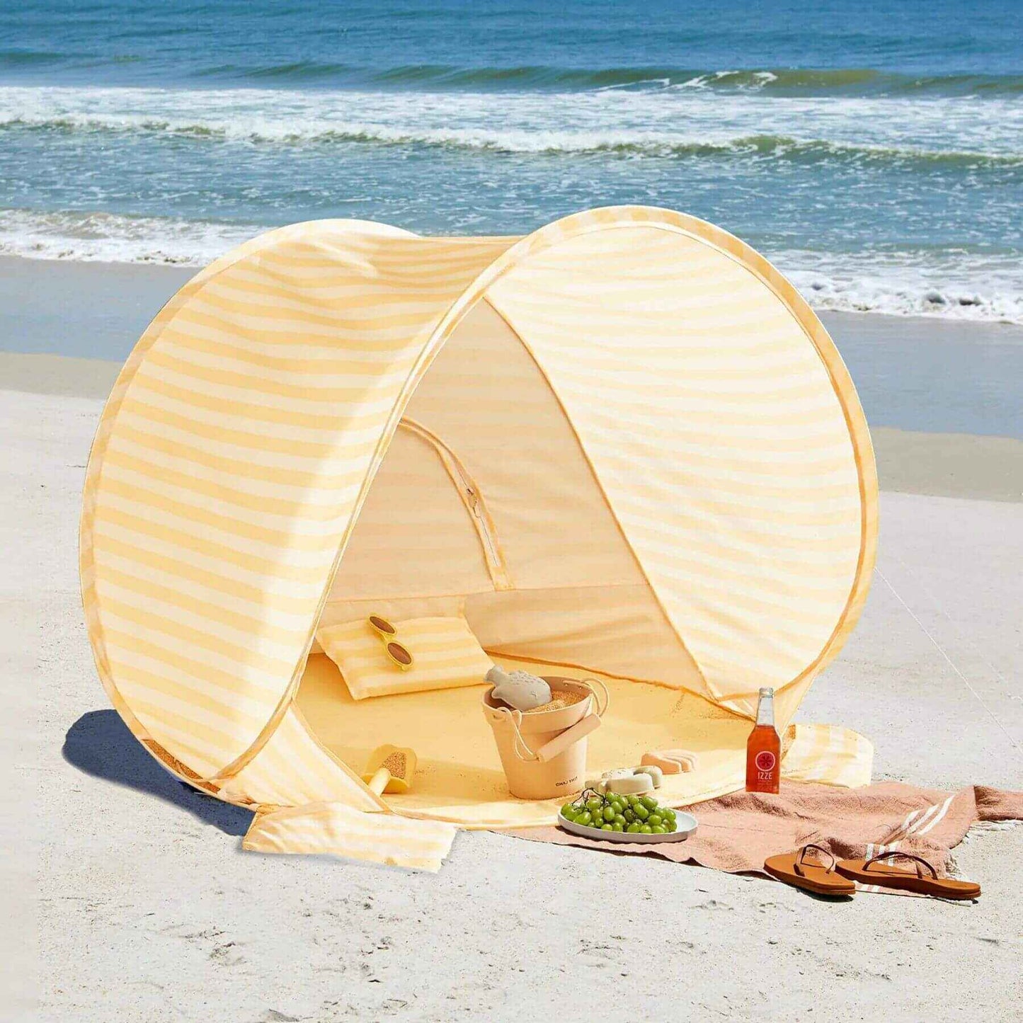 Tiny Land® One-Stop Beach Toy & Tent Set – Pastel Yellow Stripes on a sandy beach with ocean view