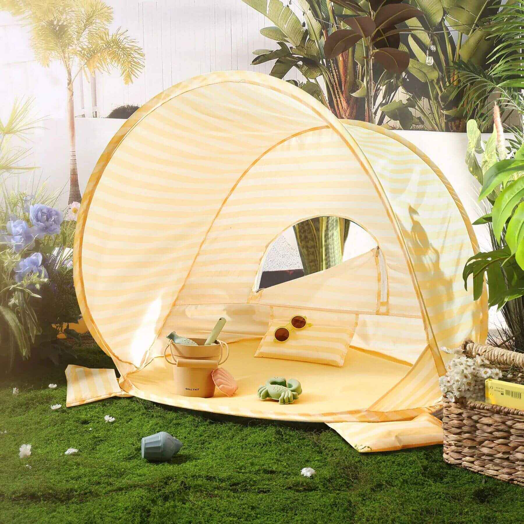 Tiny Land® One-Stop Beach Toy & Tent Set – Pastel Yellow Stripes on grass with plants and flowers in the background
