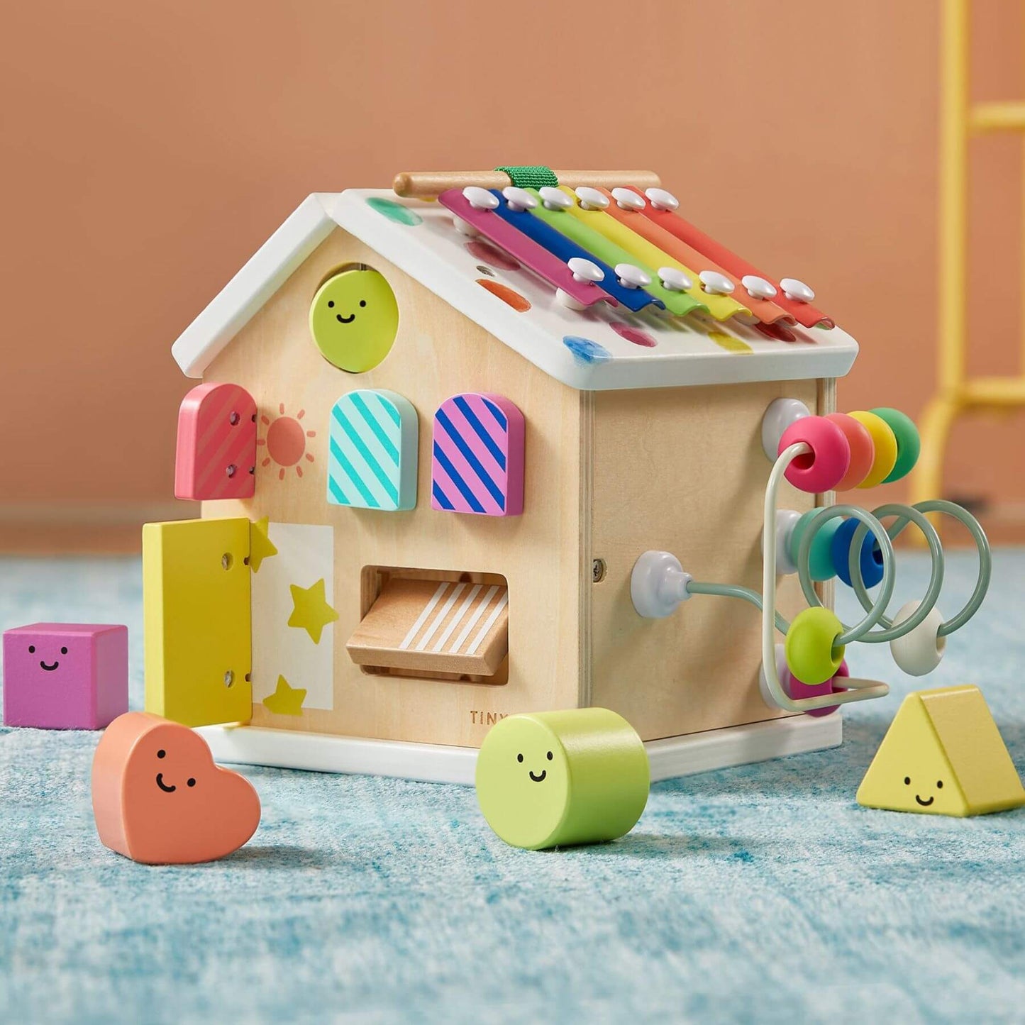 Tiny Land® Cottage Activity Cube - Rainbow on a soft surface.