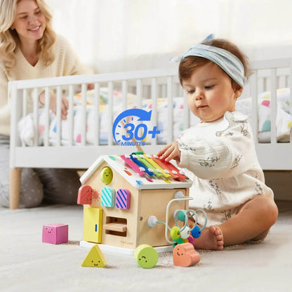 Baby playing with Tiny Land® Cottage Activity Cube - Rainbow in a nursery setting