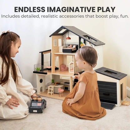 A children's wooden dollhouse playset with a garage and toy accessories, shown with two young girls sitting on the floor in a brightly lit room.