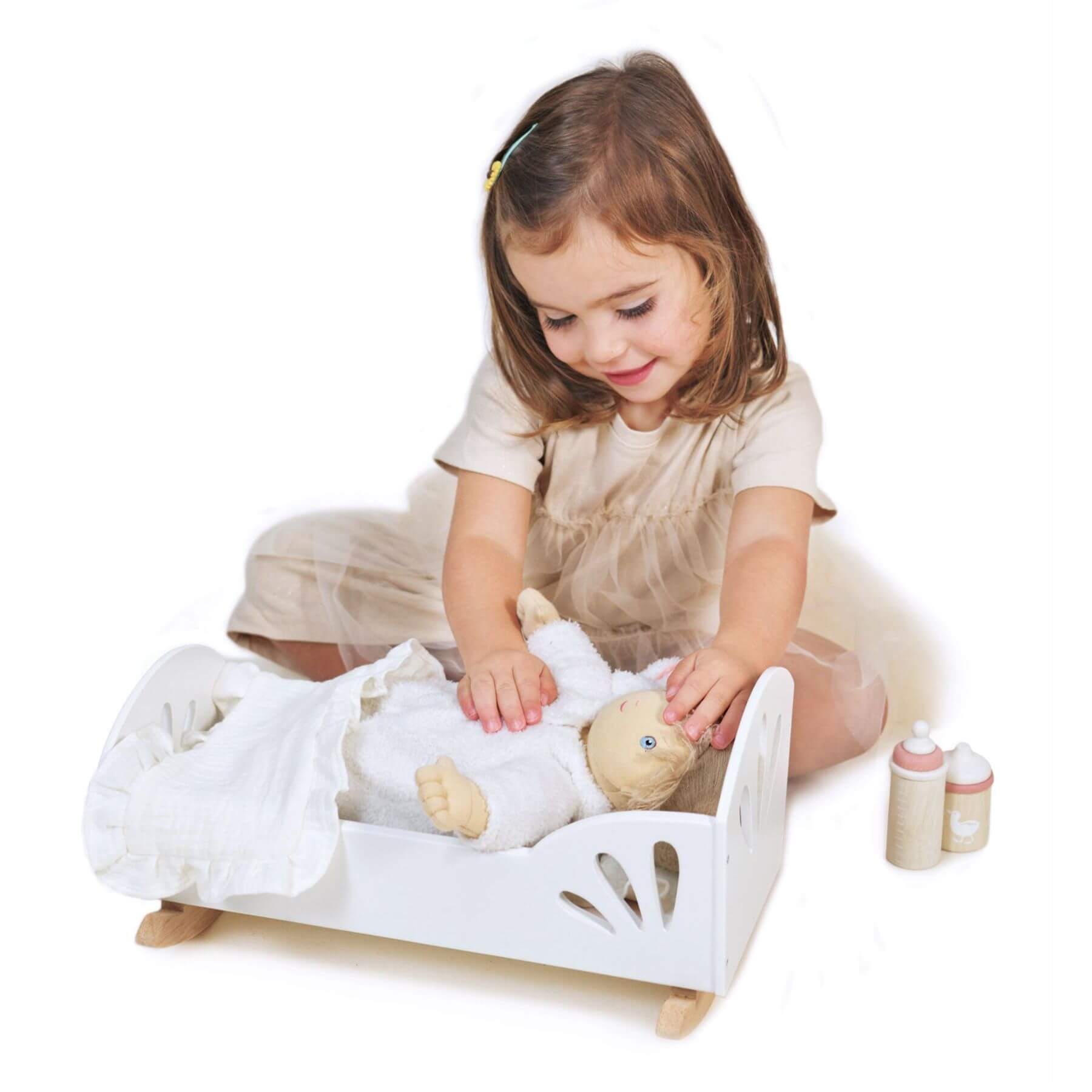 Child playing with a doll and Tender Leaf Sweet Swan Dolly Bed