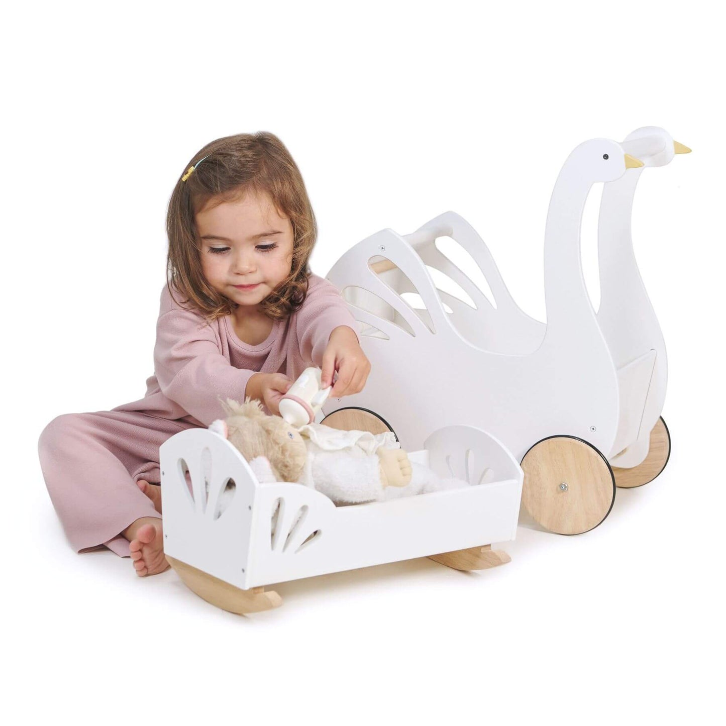 Child playing with a toy swan and boat set on a white background