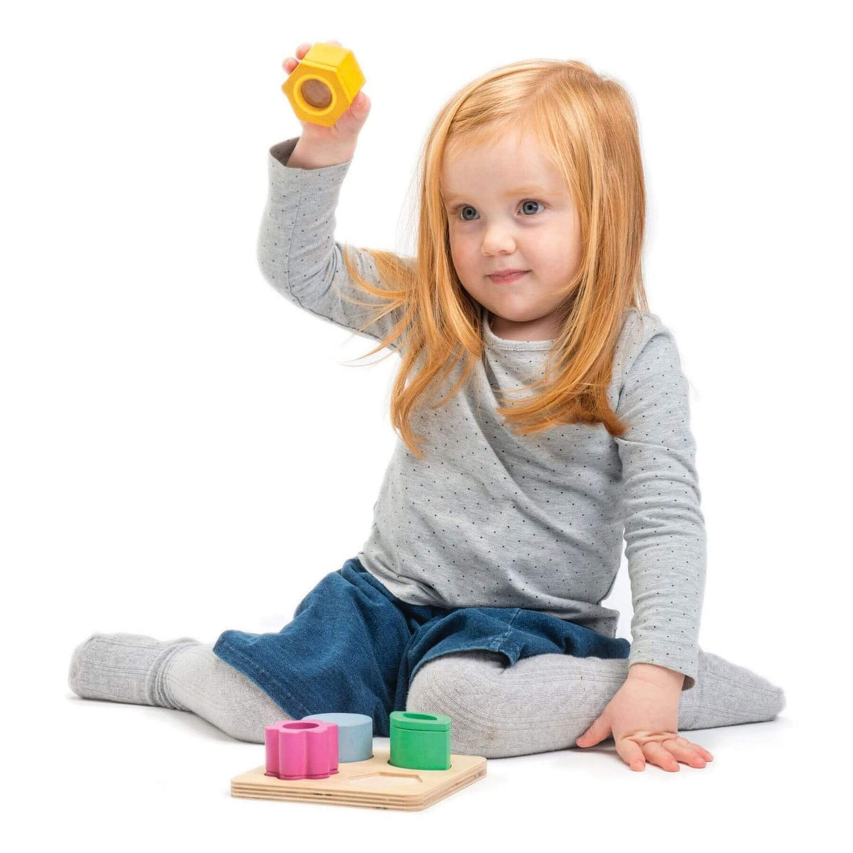 Child playing with colorful building blocks on a white background