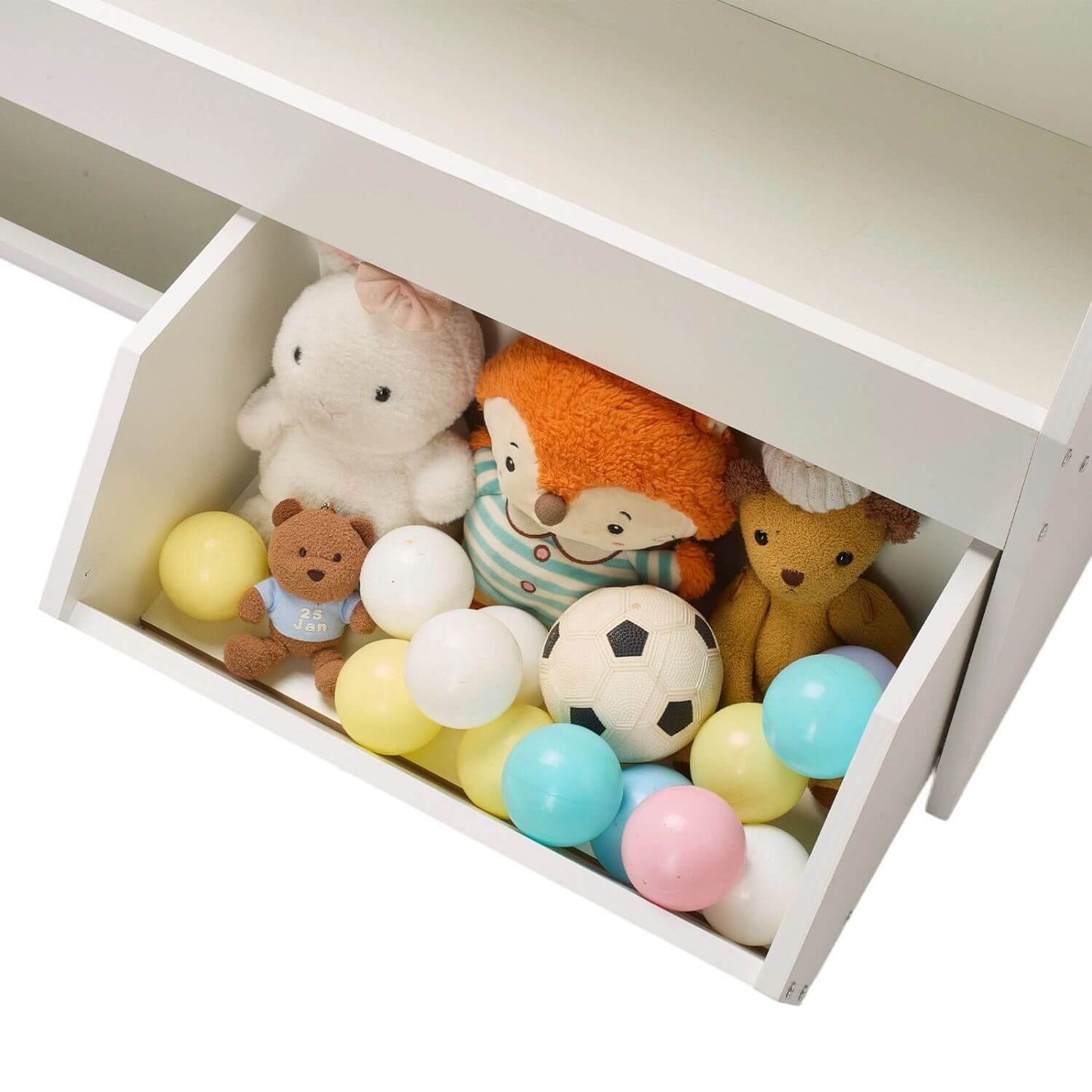 Open white drawer filled with colorful balls and plush toys on a white background