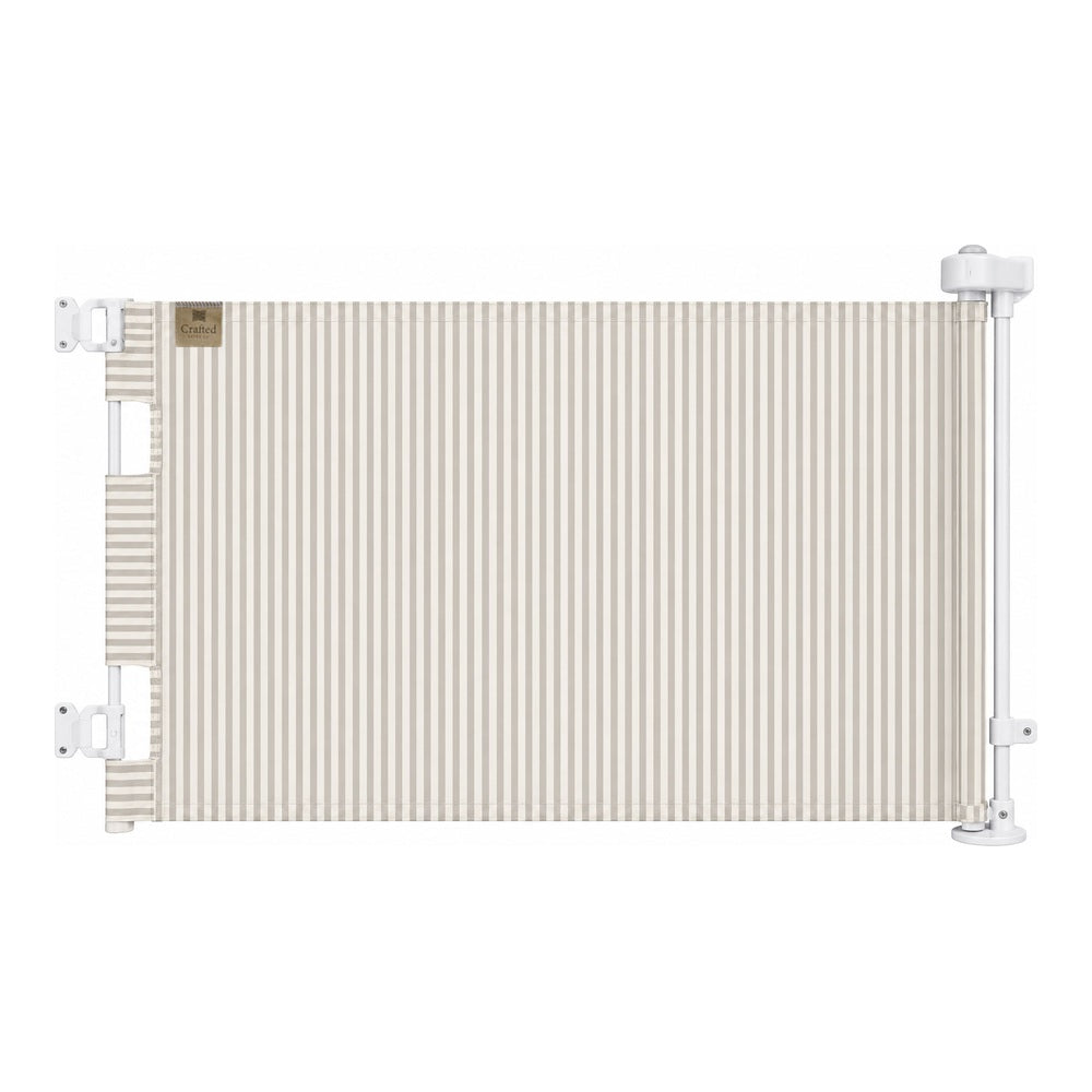 A horizontal baby safety gate with a beige and white vertical stripe pattern, mounted on a white metal frame with white brackets.