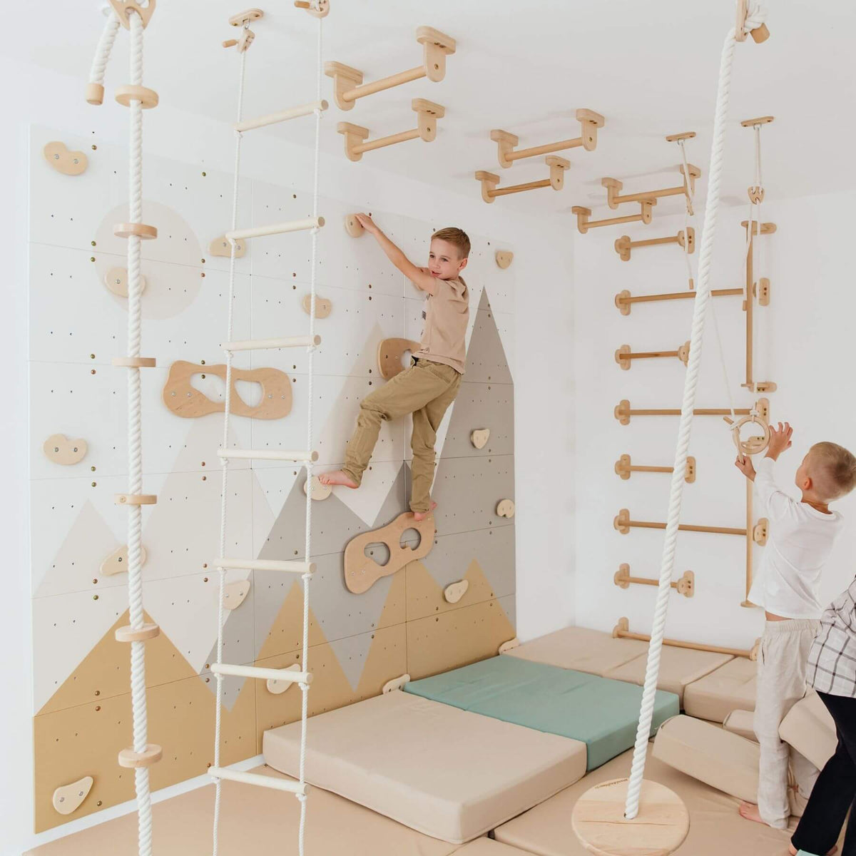 Wood and Hearts Climbing Wall Playground, and two children actively climbing in a bright white room.