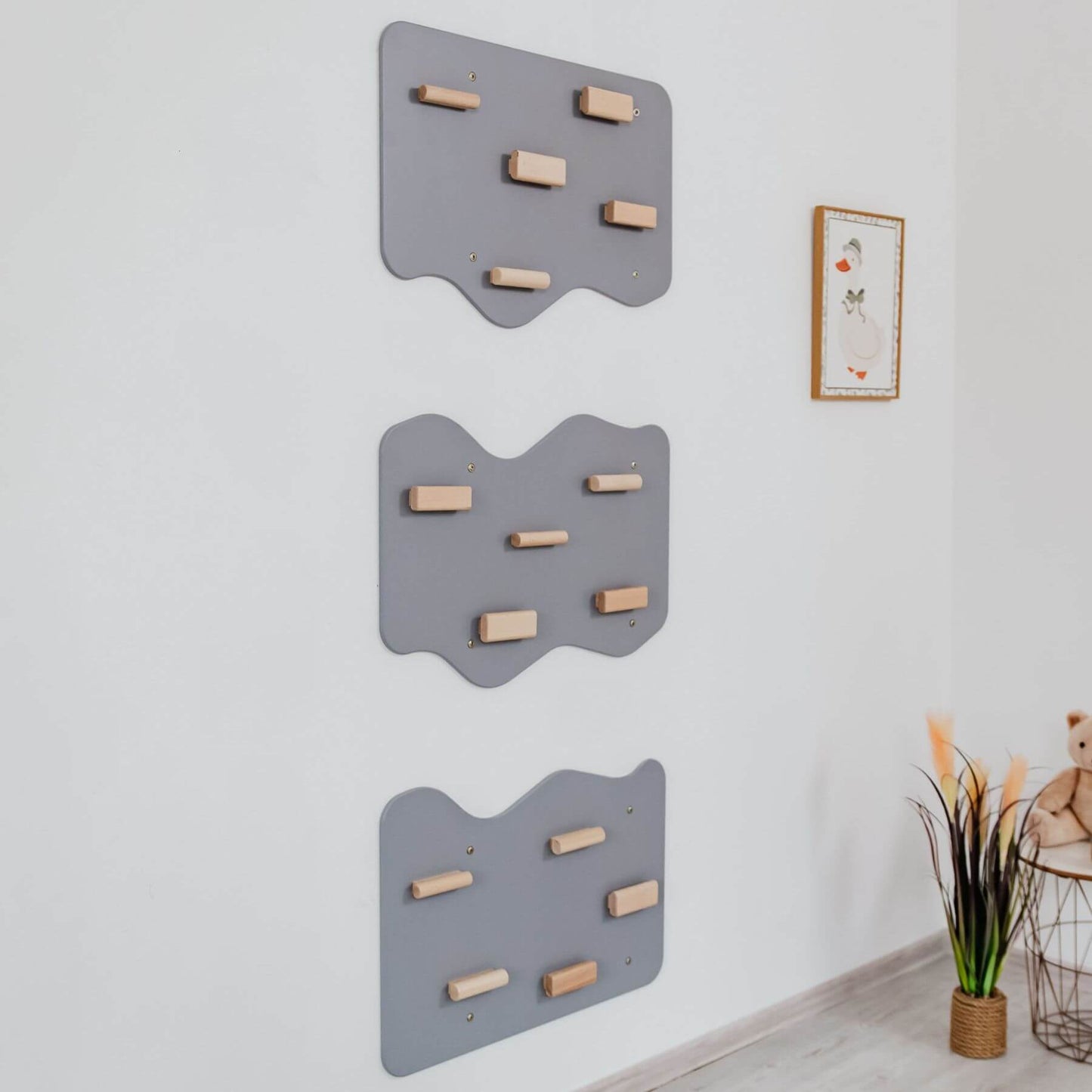 Wood and Hearts Indoor Rock Wall with Cloud-Shaped Panels & Wooden Climbing Holds - Gray on a white wall.