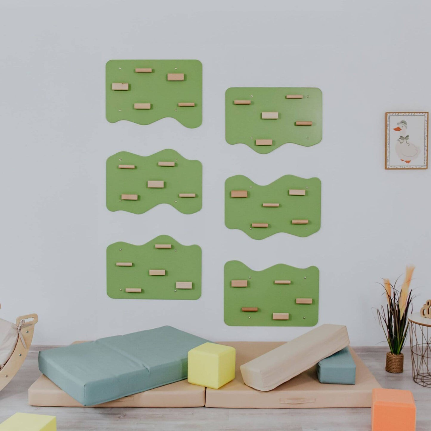 Children's play area with green climbing structures and colorful blocks on a light gray background