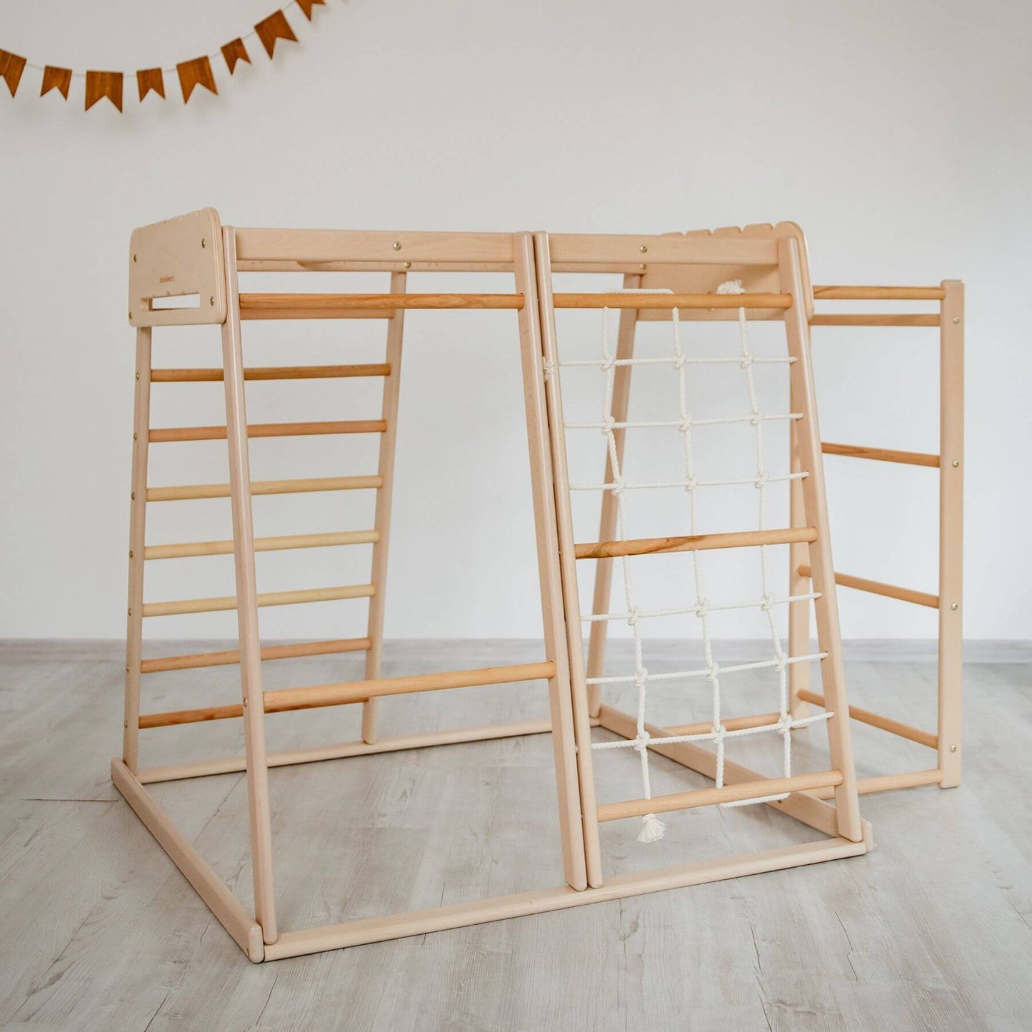 Wood and Hearts Jungle Gym Playset on a light wooden floor.