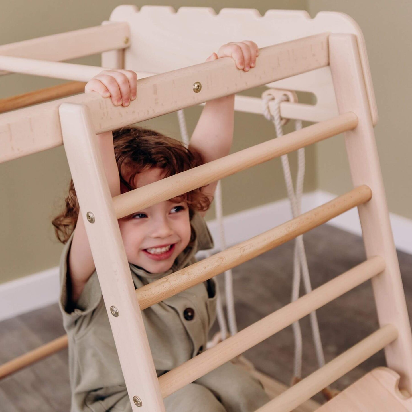 Child playing on Wood and Hearts Jungle Gym Playset indoors