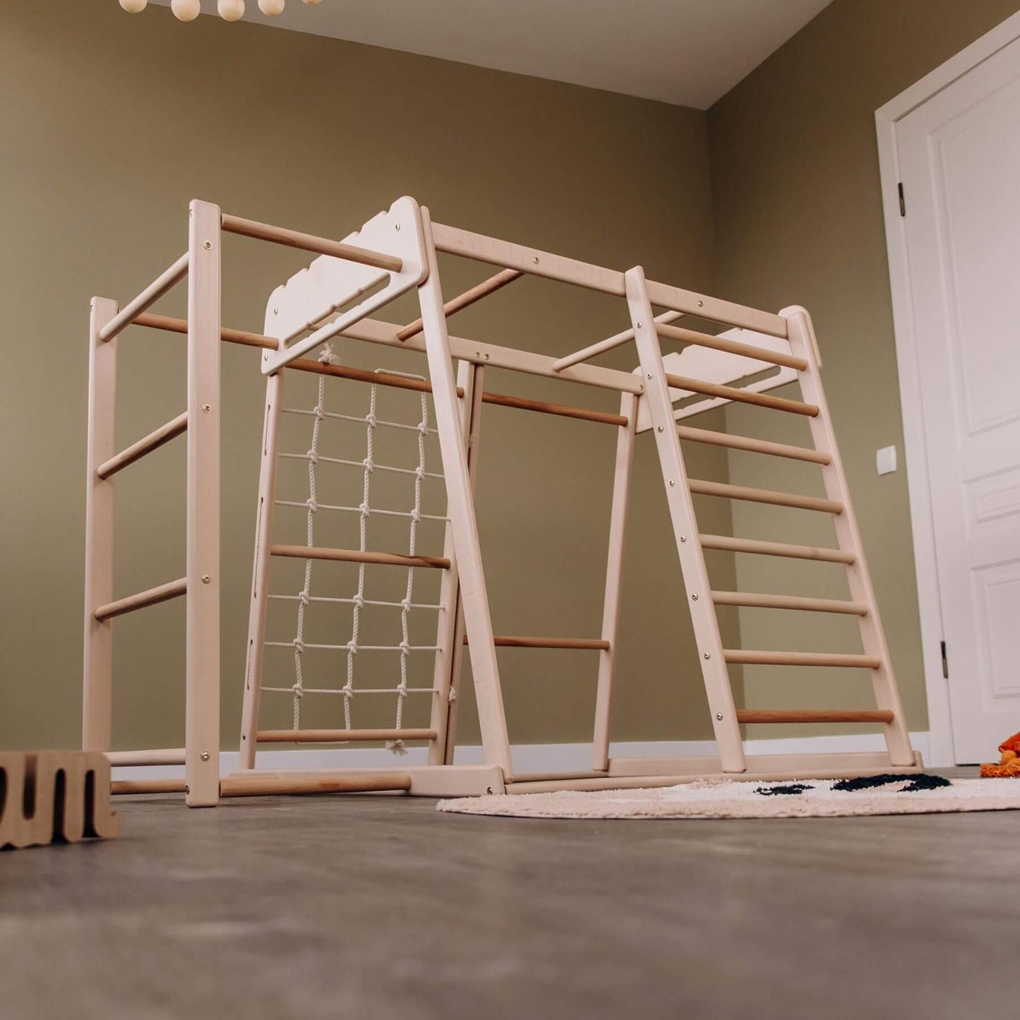 Wood and Hearts Jungle Gym Playset in a room.