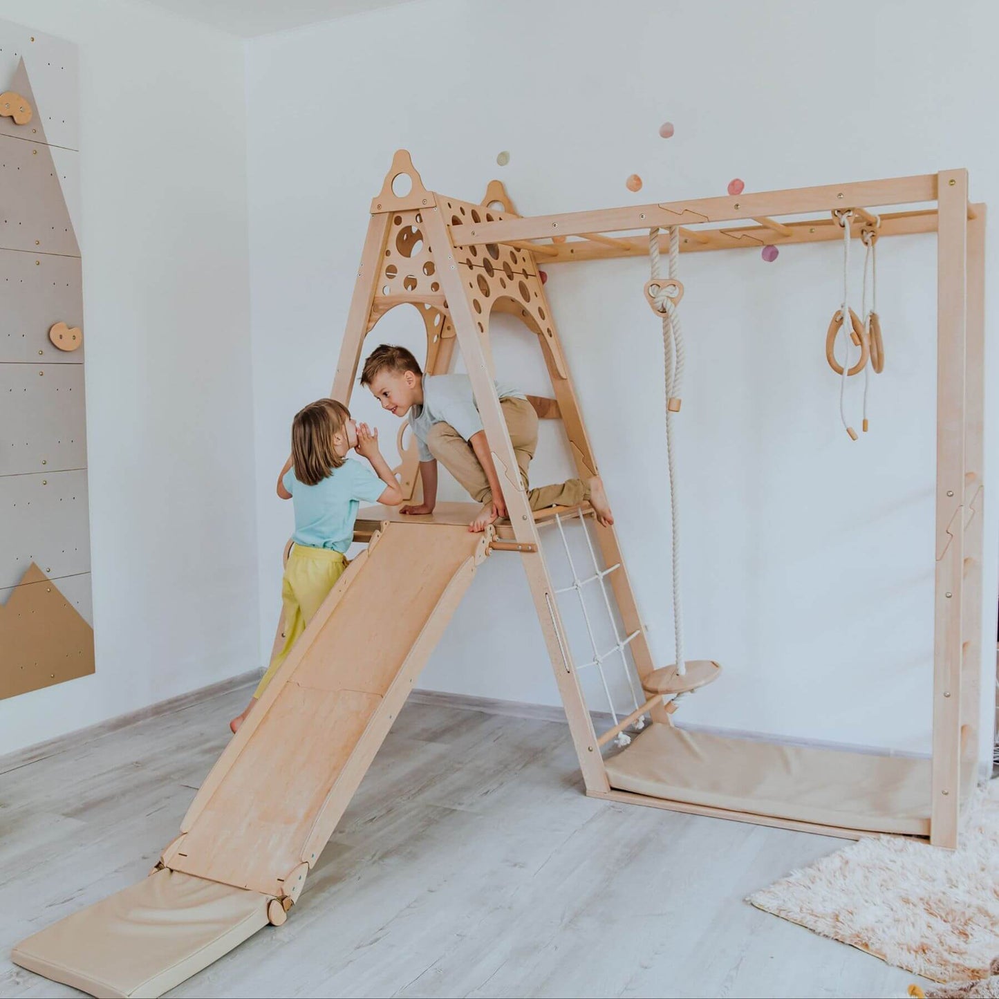 Children playing on Wood and Hearts Kid Climbing Structure in a room.