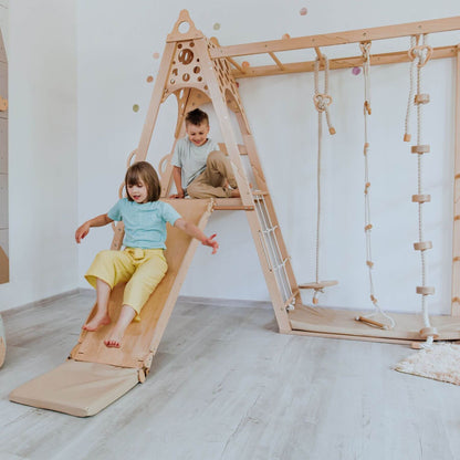 Two children playing on Wood and Hearts Kid Climbing Structure in a room.