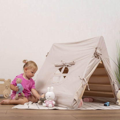 Child playing with toys in front of a beige play tent indoors.