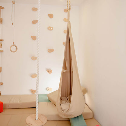 Children's playroom with climbing wall, swing, and Wood and Hearts Pod Swing