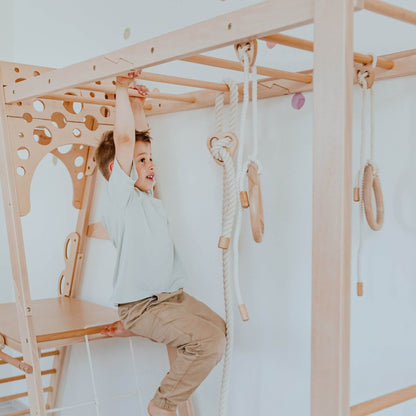 Child playing on Wood and Hearts Wooden Playground indoors